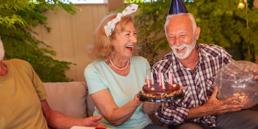 Elderly Couple Laughing With Birthday Cake in Independent Living