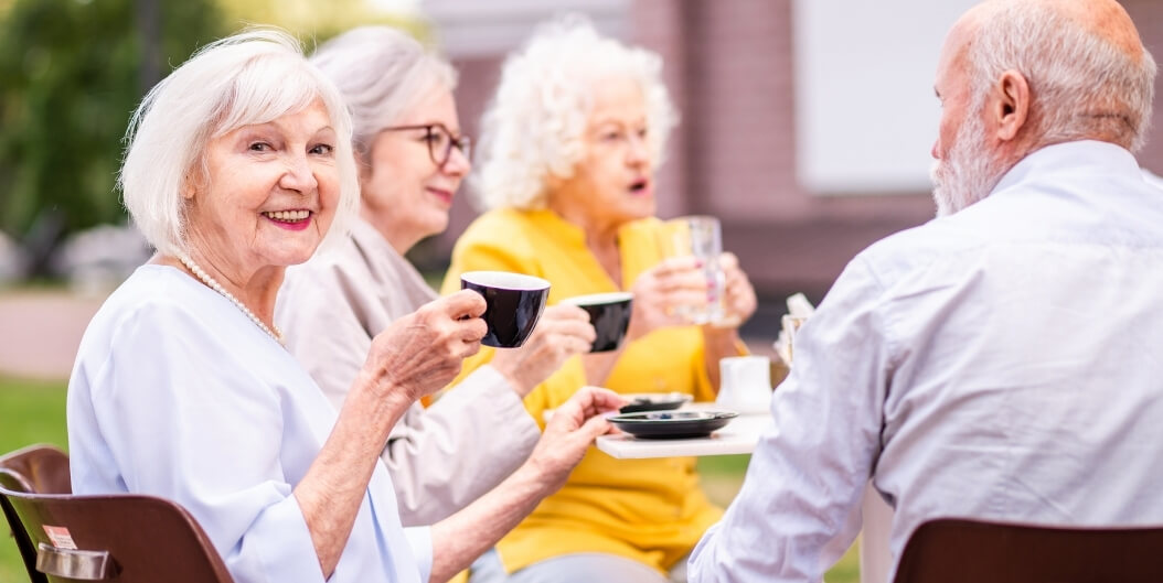 Elderly Friends Socializing Outdoors at Independent Living Facility in Mobile Alabama