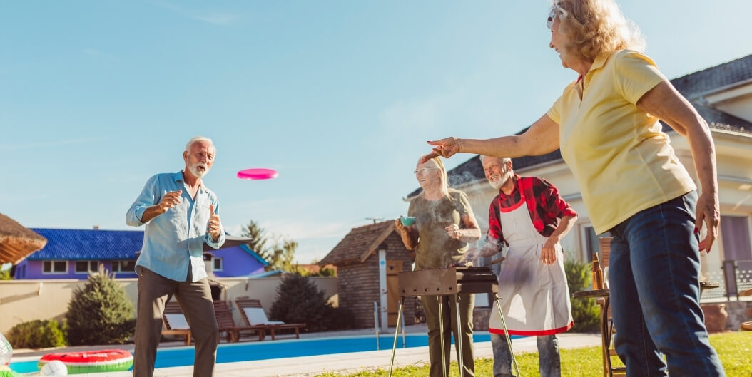 Group of Seniors Playing Frisbee and Grilling Outdoors at an Independent Living Facility