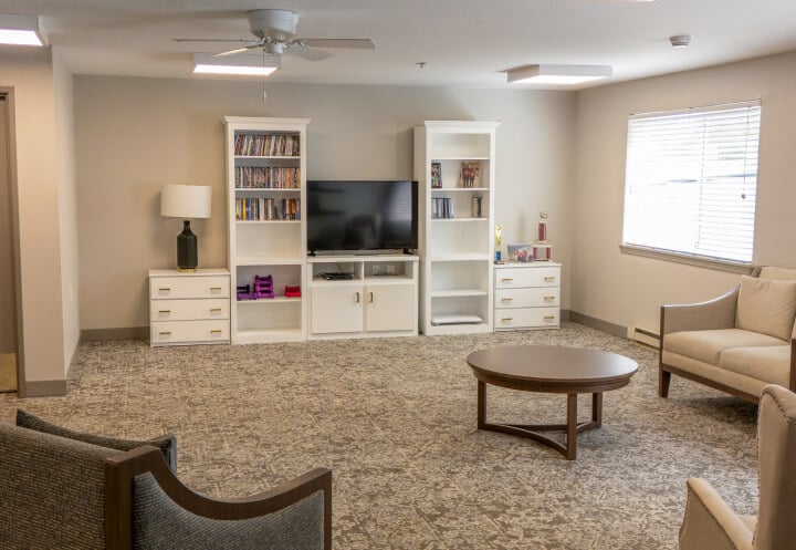 Comfortable Living Room with Bookshelves and Television at Independent Living Facility