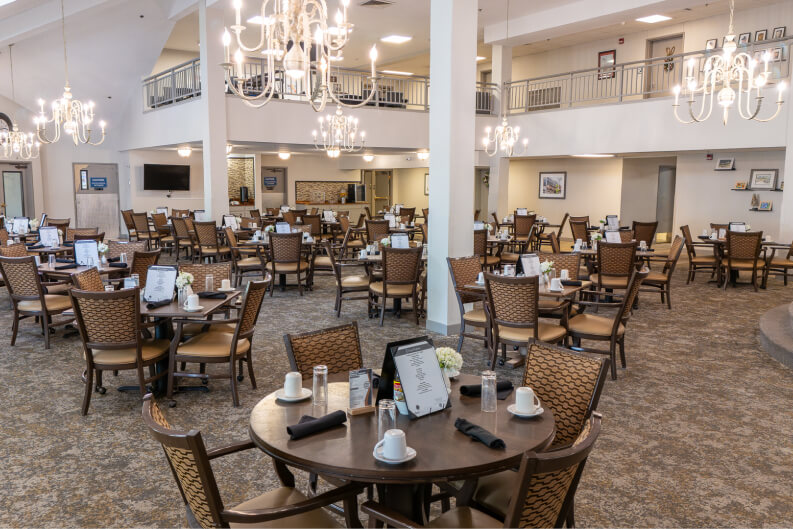 Elegant Dining Hall with Chandeliers and Round Tables at Independent Living Facility Elegant Dining Hall with Chandeliers and Round Tables at Independent Living Facility