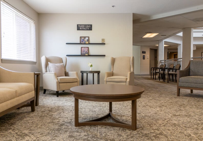Cozy Sitting Area with Wingback Chairs and Coffee Table at Independent Living Facility