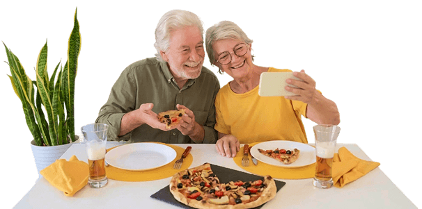Smiling Elderly Couple Taking a Selfie Over Pizza at an Independent Living Facility Smiling Elderly Couple Taking a Selfie Over Pizza at an Independent Living Facility