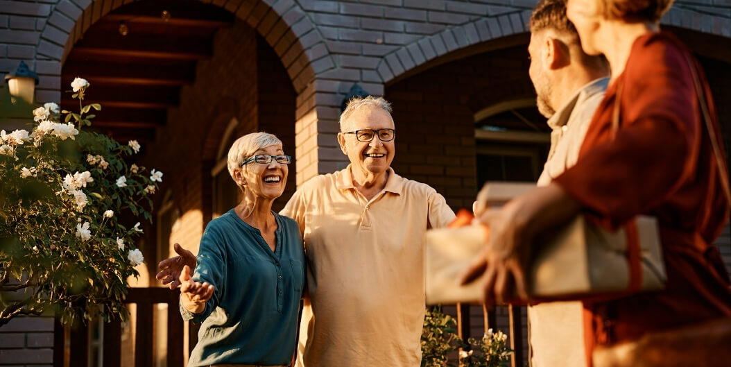 Elderly Couple Greeting Visitors Warmly at Independent Living Facility
