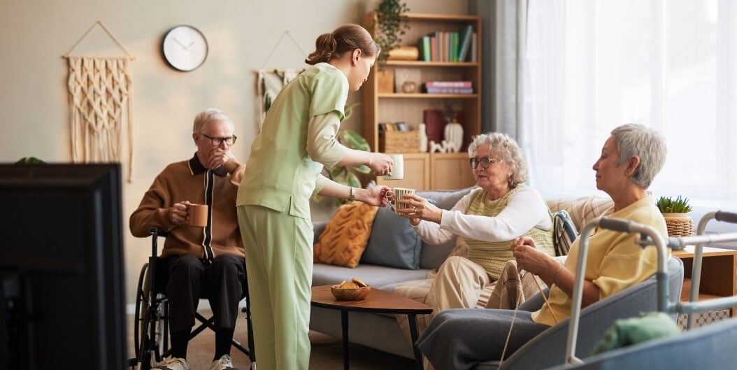 Female Nurse Serving Tea to Elderly Residents at Independent Facility